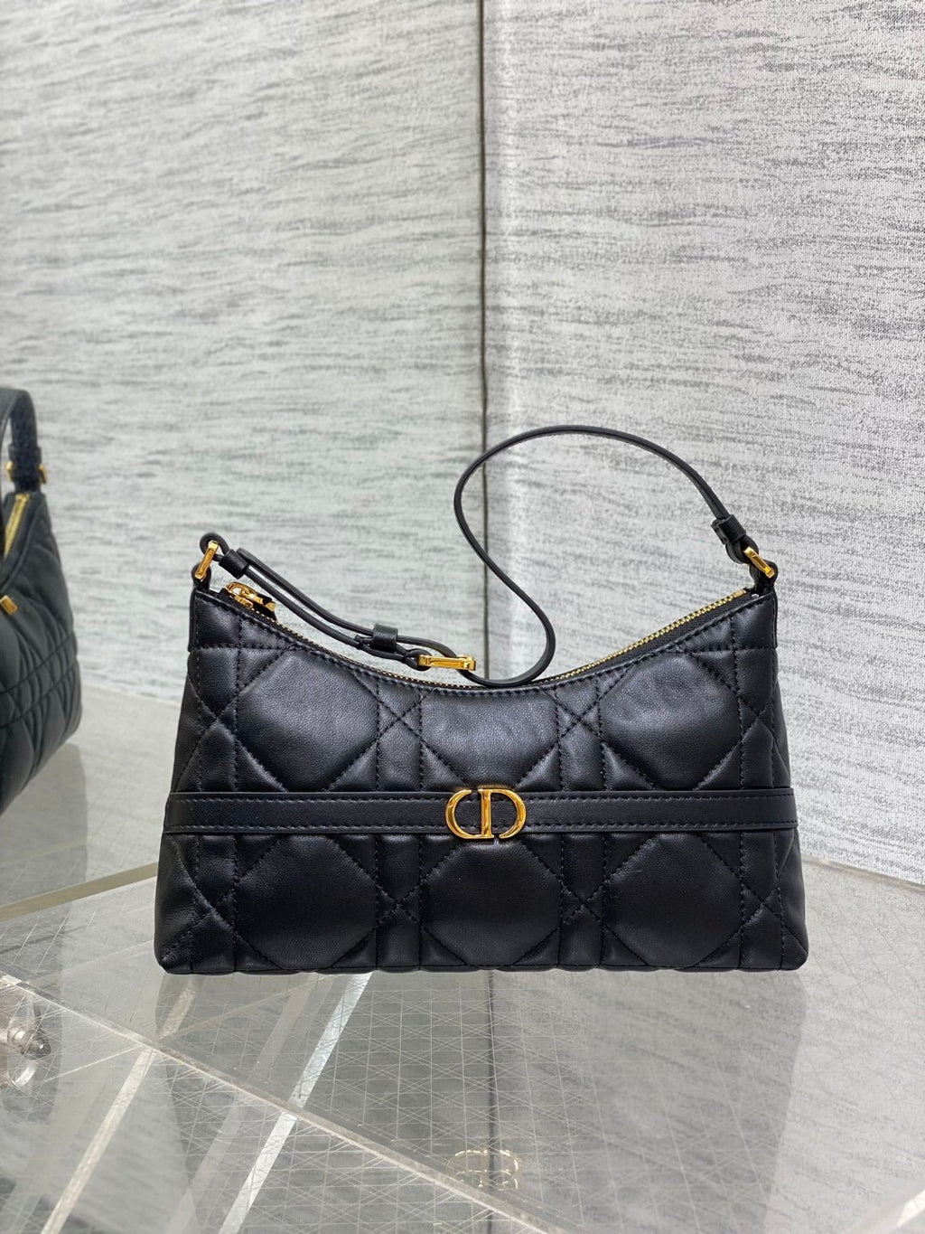 Dior Miss Caro mini hobo shoulder bag in black Macrocannage lambskin with a gold-finish metal CD signature and chain strap.