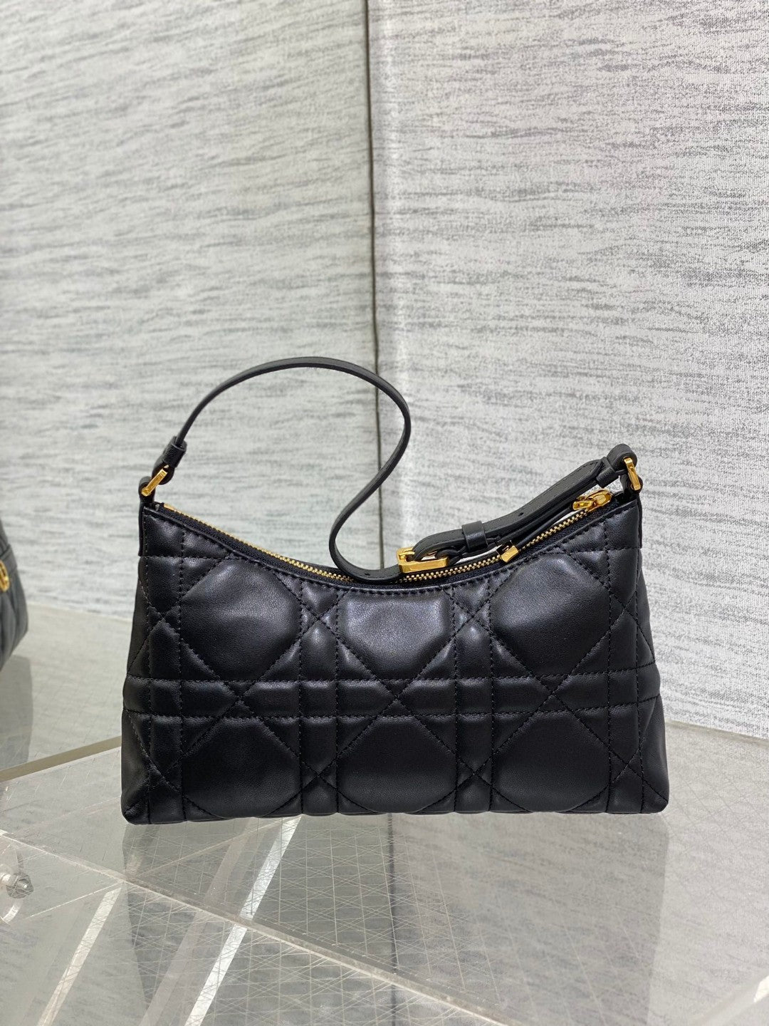 Dior Miss Caro mini hobo shoulder bag in black Macrocannage lambskin with a gold-finish metal CD signature and chain strap.