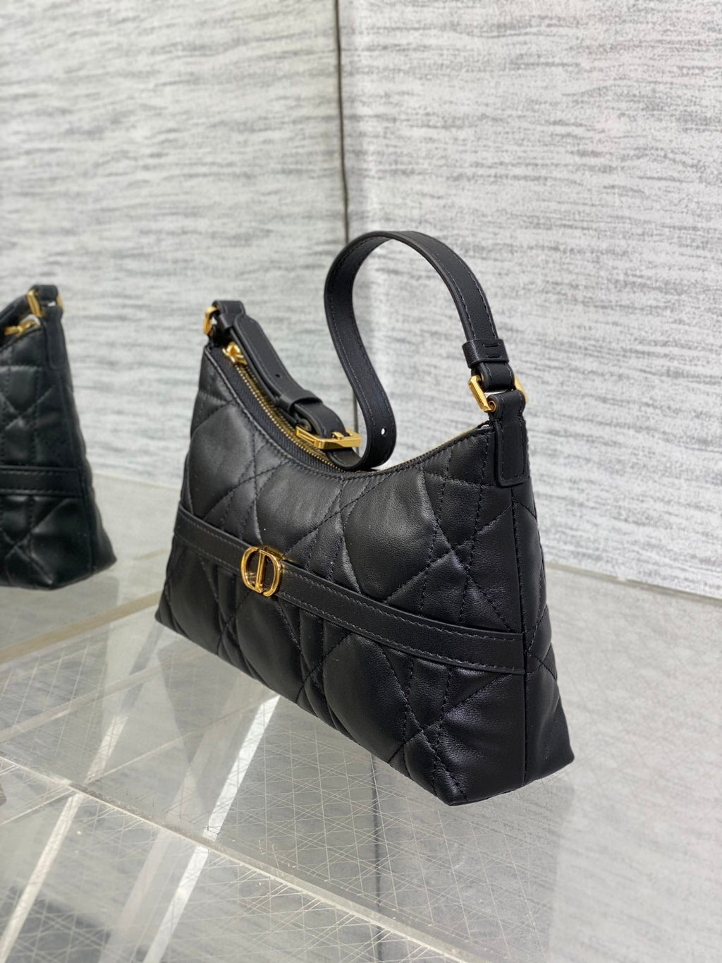 Dior Miss Caro mini hobo shoulder bag in black Macrocannage lambskin with a gold-finish metal CD signature and chain strap.
