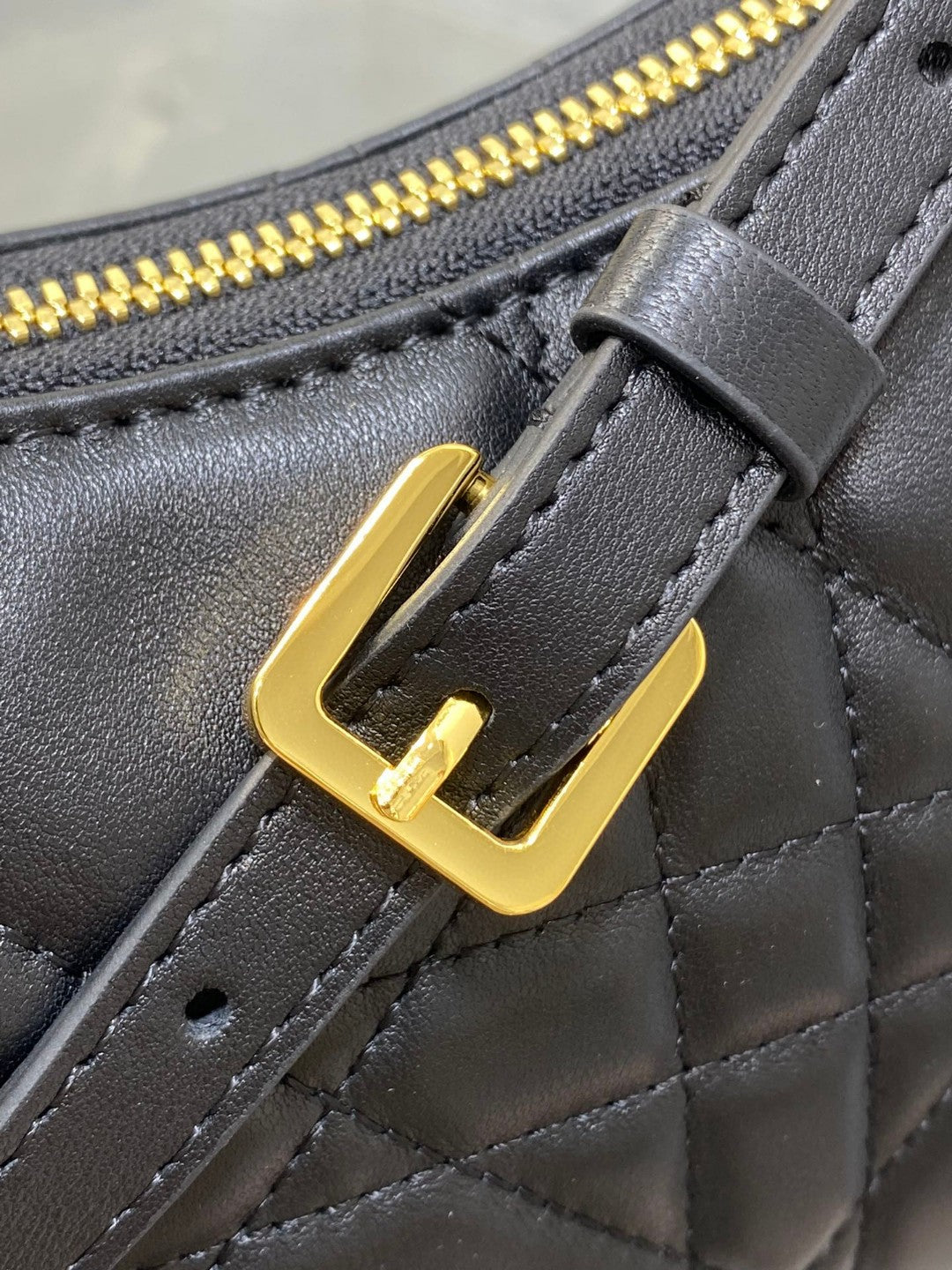 Dior Miss Caro mini hobo shoulder bag in black Macrocannage lambskin with a gold-finish metal CD signature and chain strap.