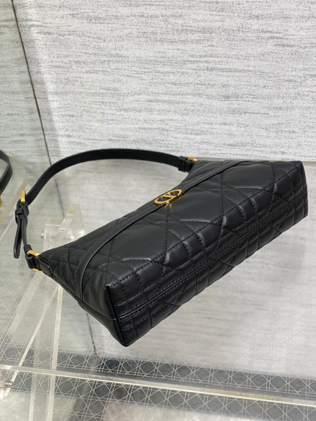 Dior Miss Caro mini hobo shoulder bag in black Macrocannage lambskin with a gold-finish metal CD signature and chain strap.