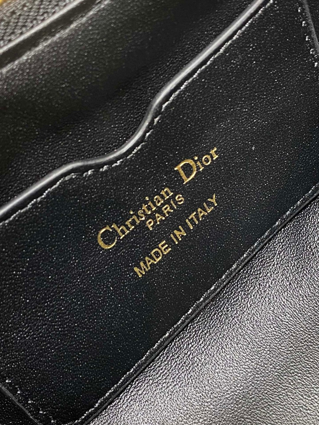 Dior Miss Caro mini hobo shoulder bag in black Macrocannage lambskin with a gold-finish metal CD signature and chain strap.