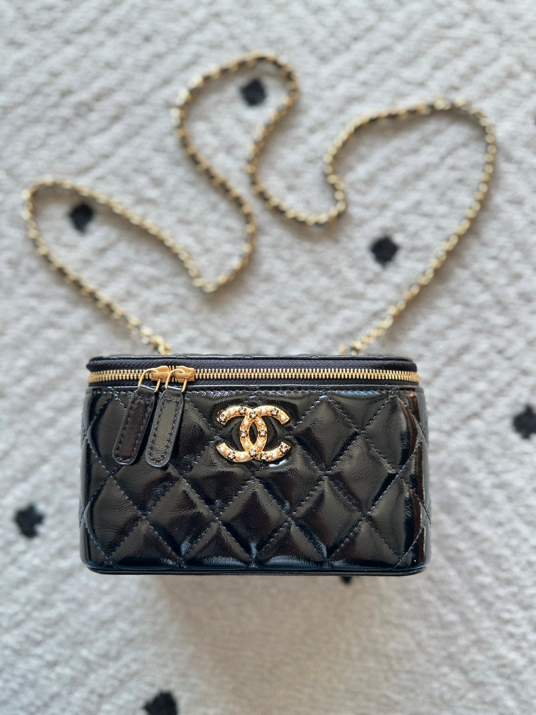 black Chanel Vanity Case with a gold-tone chain strap and hardware