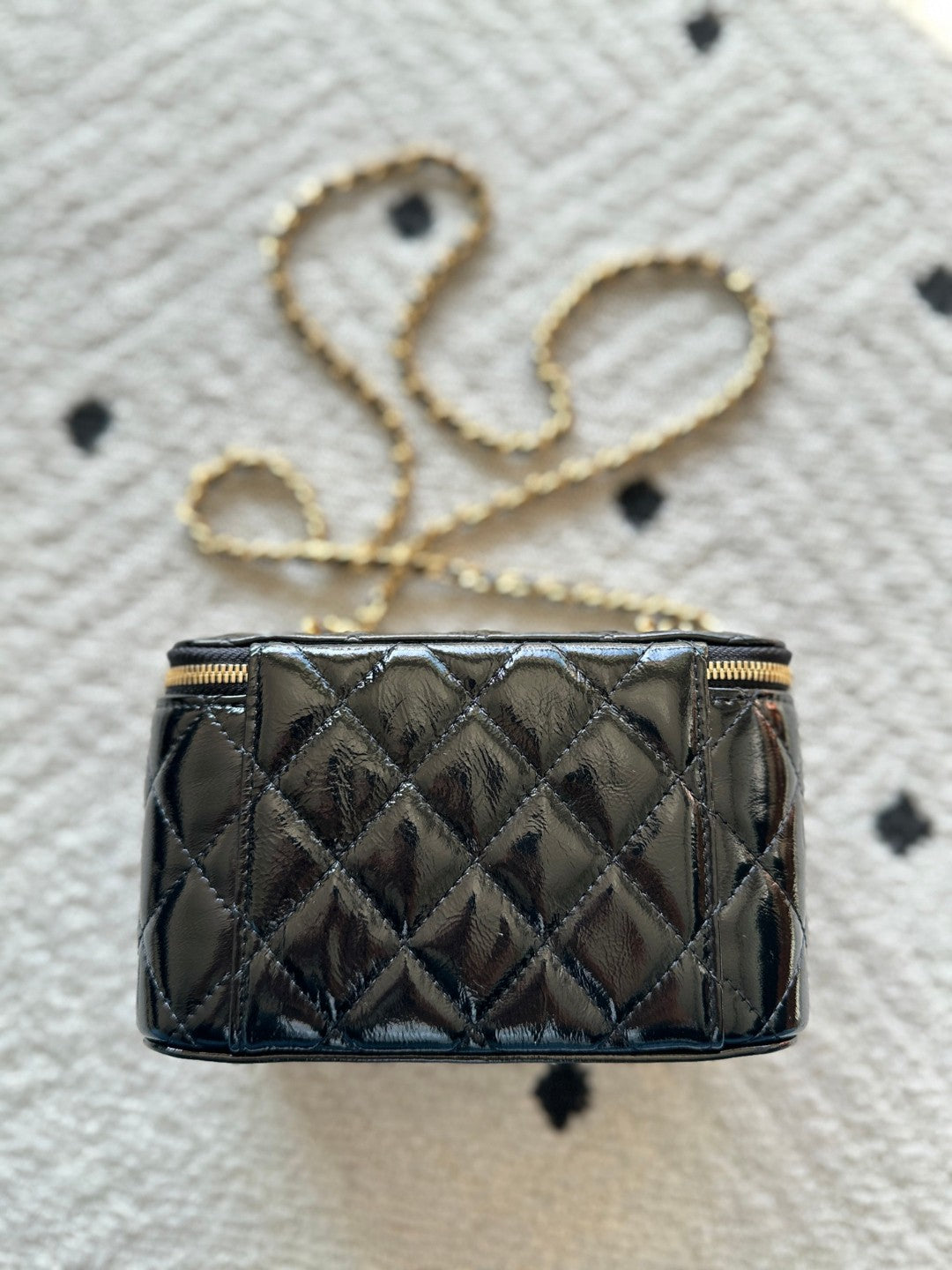 black Chanel Vanity Case with a gold-tone chain strap and hardware