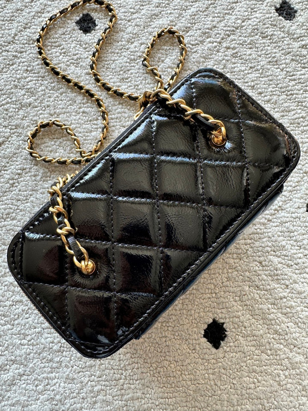 black Chanel Vanity Case with a gold-tone chain strap and hardware