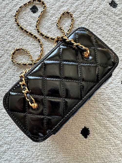 black Chanel Vanity Case with a gold-tone chain strap and hardware