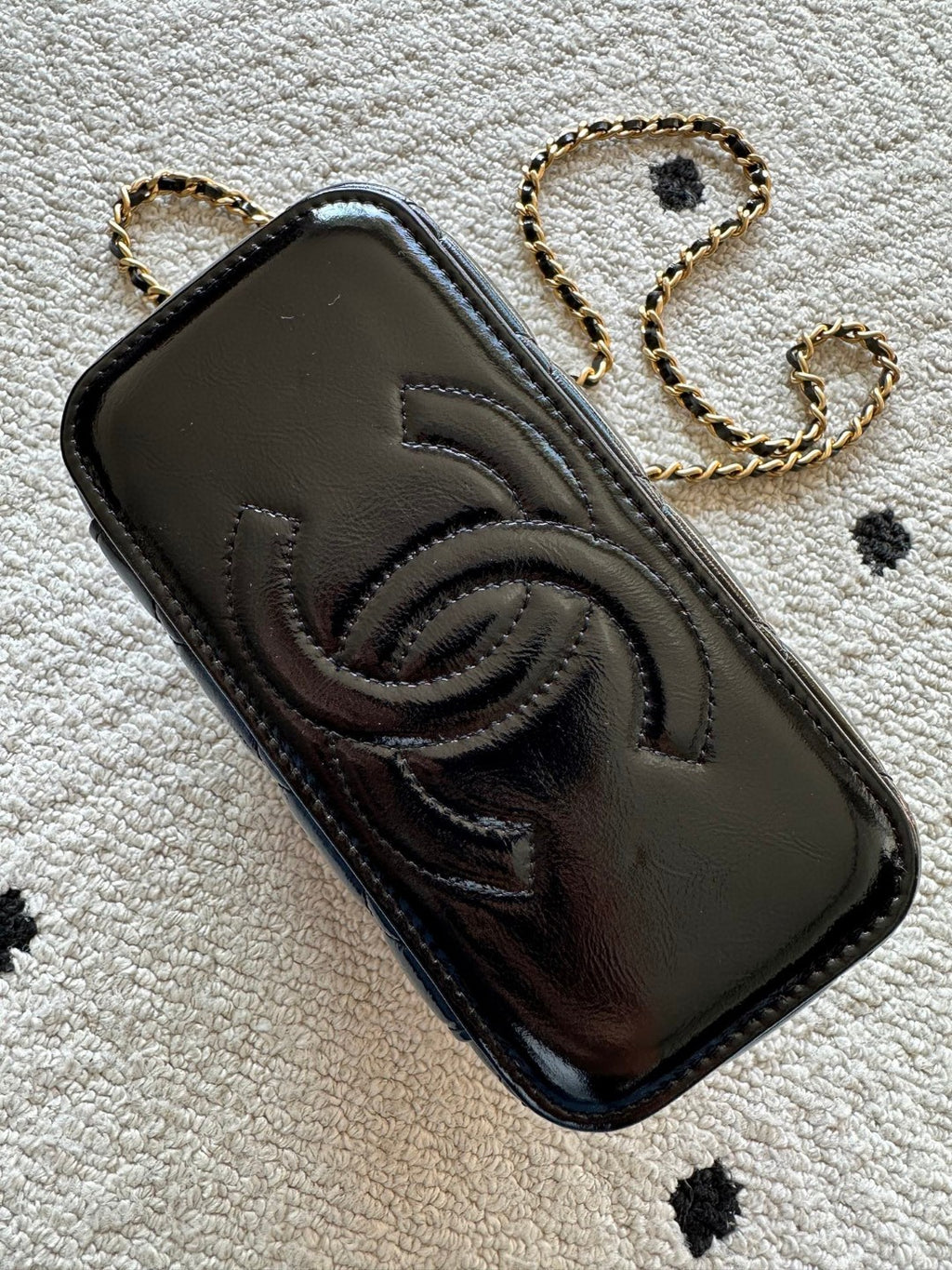 black Chanel Vanity Case with a gold-tone chain strap and hardware