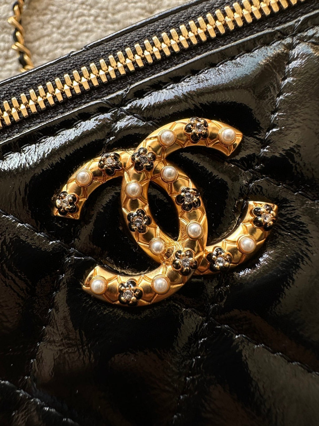 black Chanel Vanity Case with a gold-tone chain strap and hardware