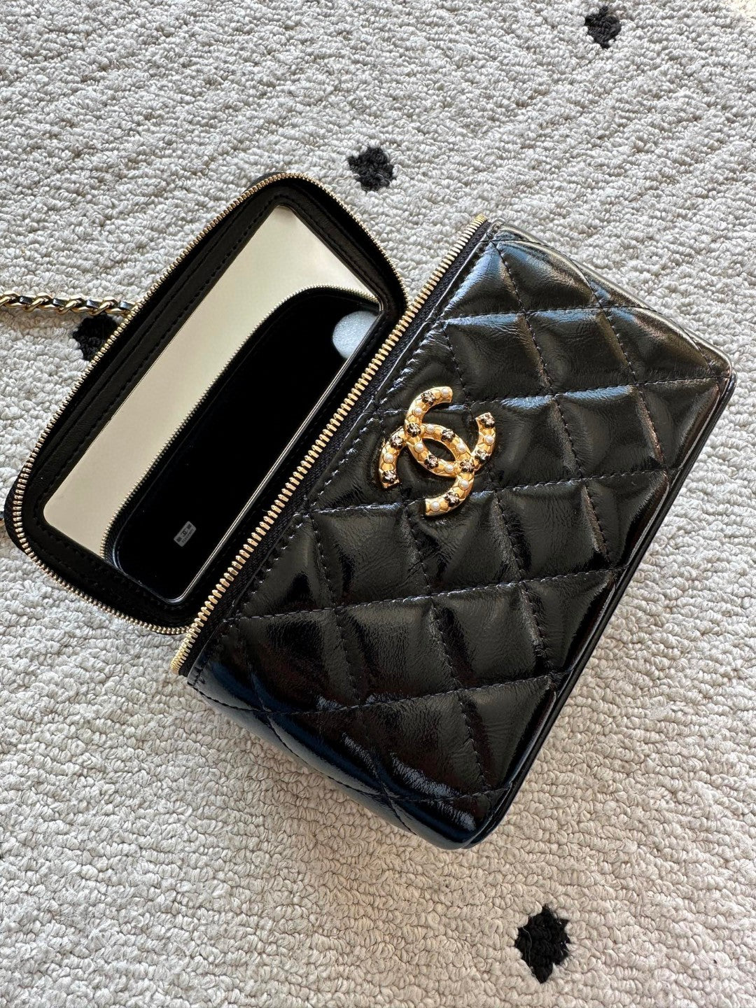 black Chanel Vanity Case with a gold-tone chain strap and hardware