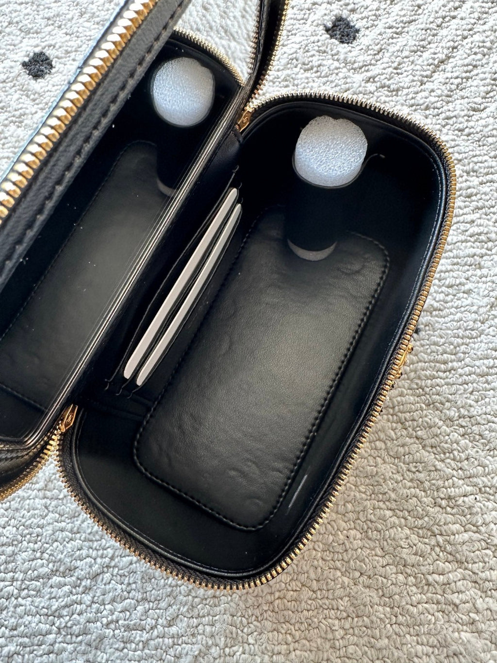 black Chanel Vanity Case with a gold-tone chain strap and hardware