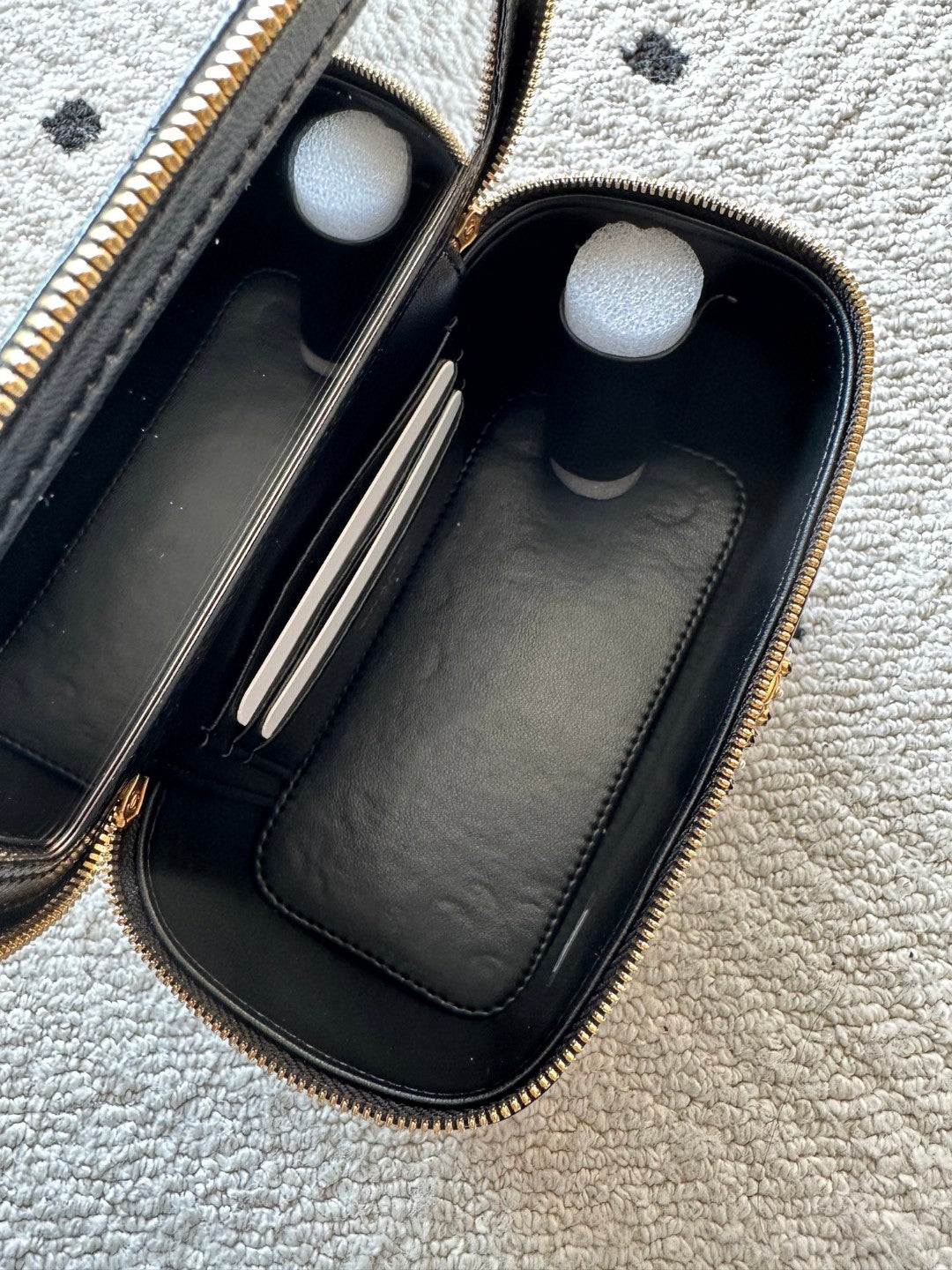 black Chanel Vanity Case with a gold-tone chain strap and hardware