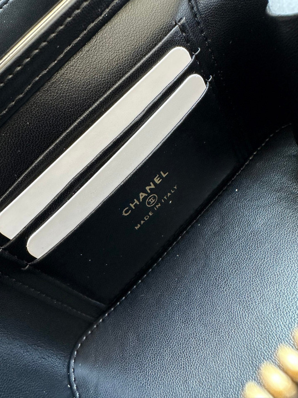 black Chanel Vanity Case with a gold-tone chain strap and hardware