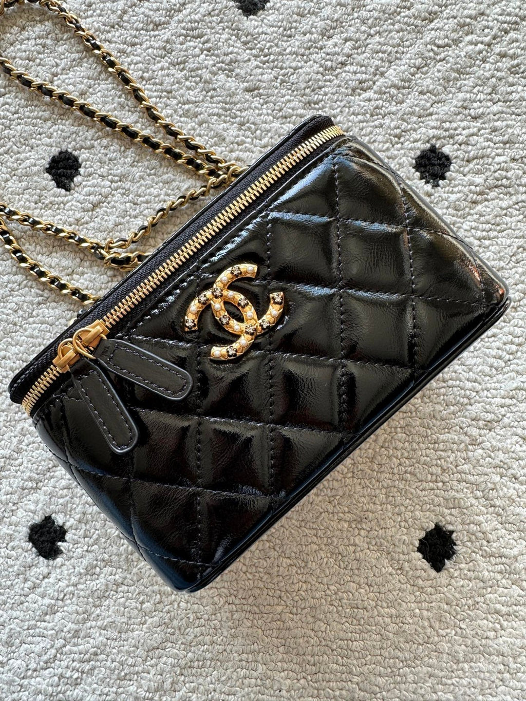 black Chanel Vanity Case with a gold-tone chain strap and hardware