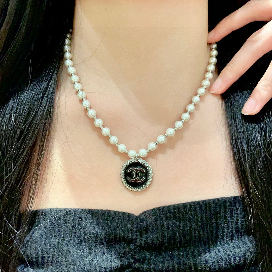 Chanel pearl necklace featuring the iconic double C logo charm