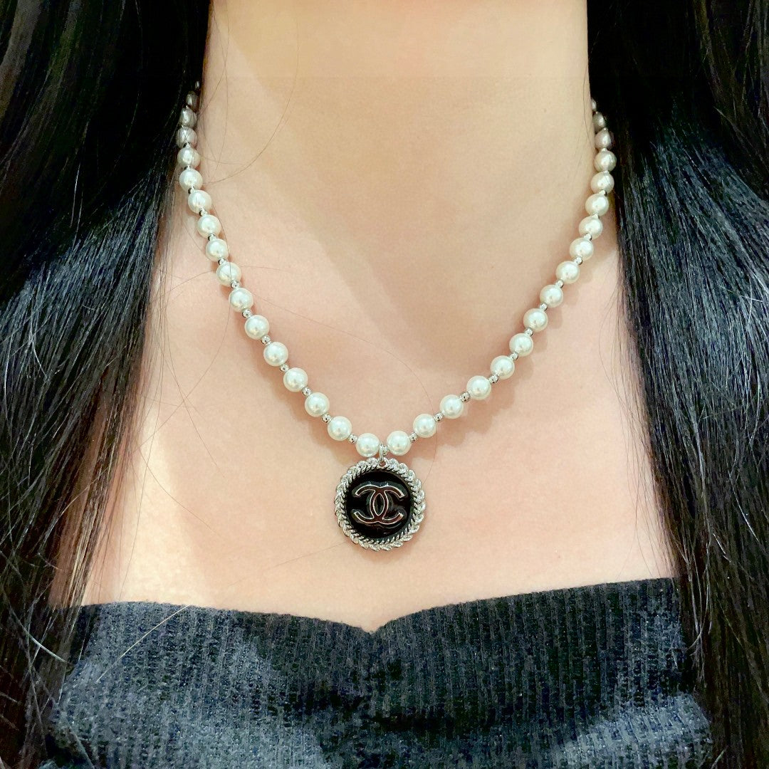 Chanel pearl necklace featuring the iconic double C logo charm