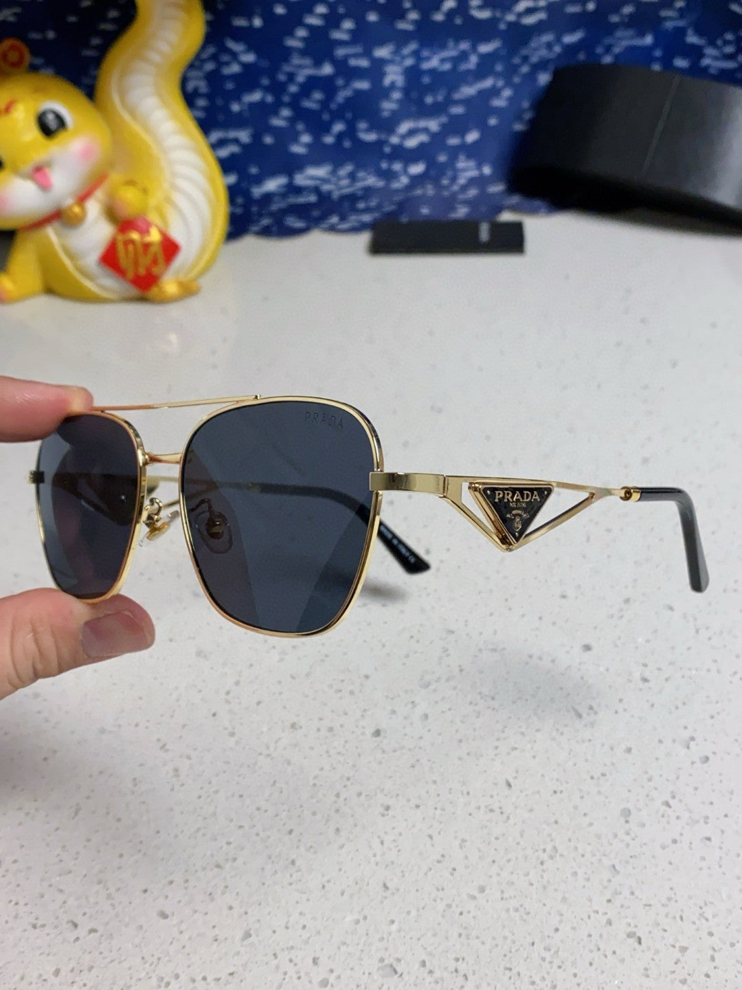 Prada aviator sunglasses with a gold metal frame and blue/grey lenses