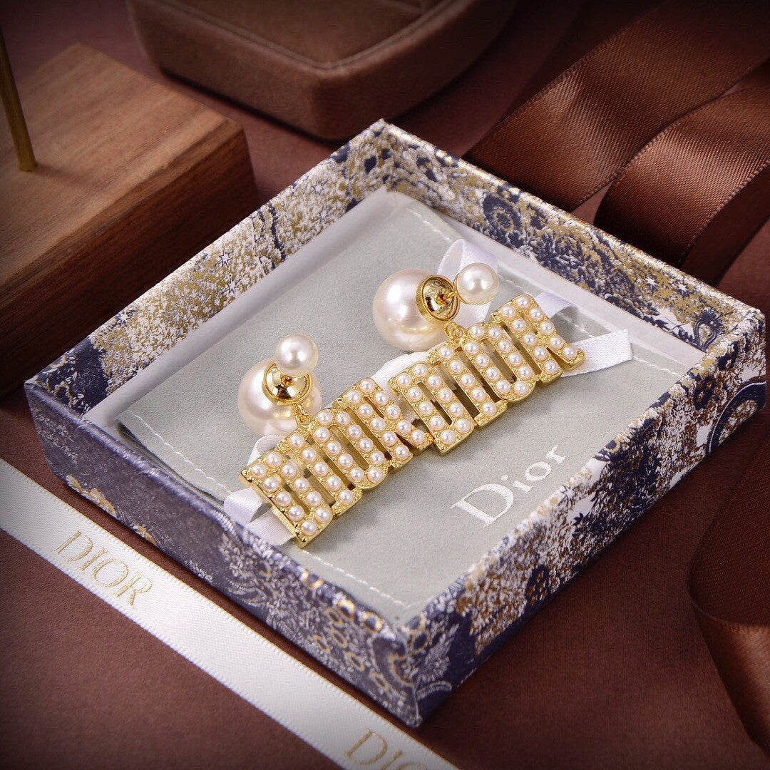 Dior Tribales earrings featuring white resin pearls and gold-finish metal D.I.O.R. letters