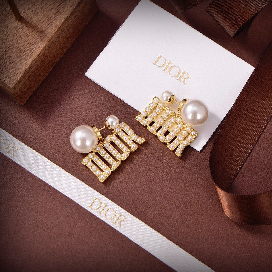 Dior Tribales earrings featuring white resin pearls and gold-finish metal D.I.O.R. letters