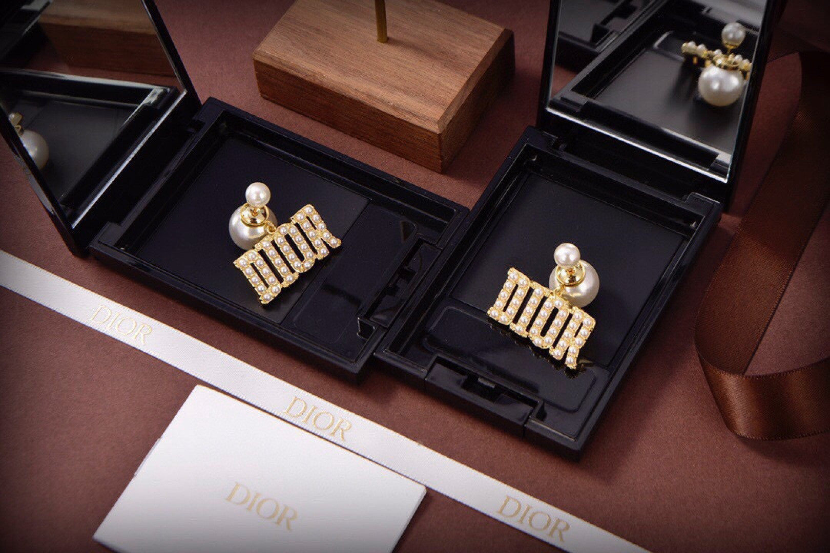 Dior Tribales earrings featuring white resin pearls and gold-finish metal D.I.O.R. letters