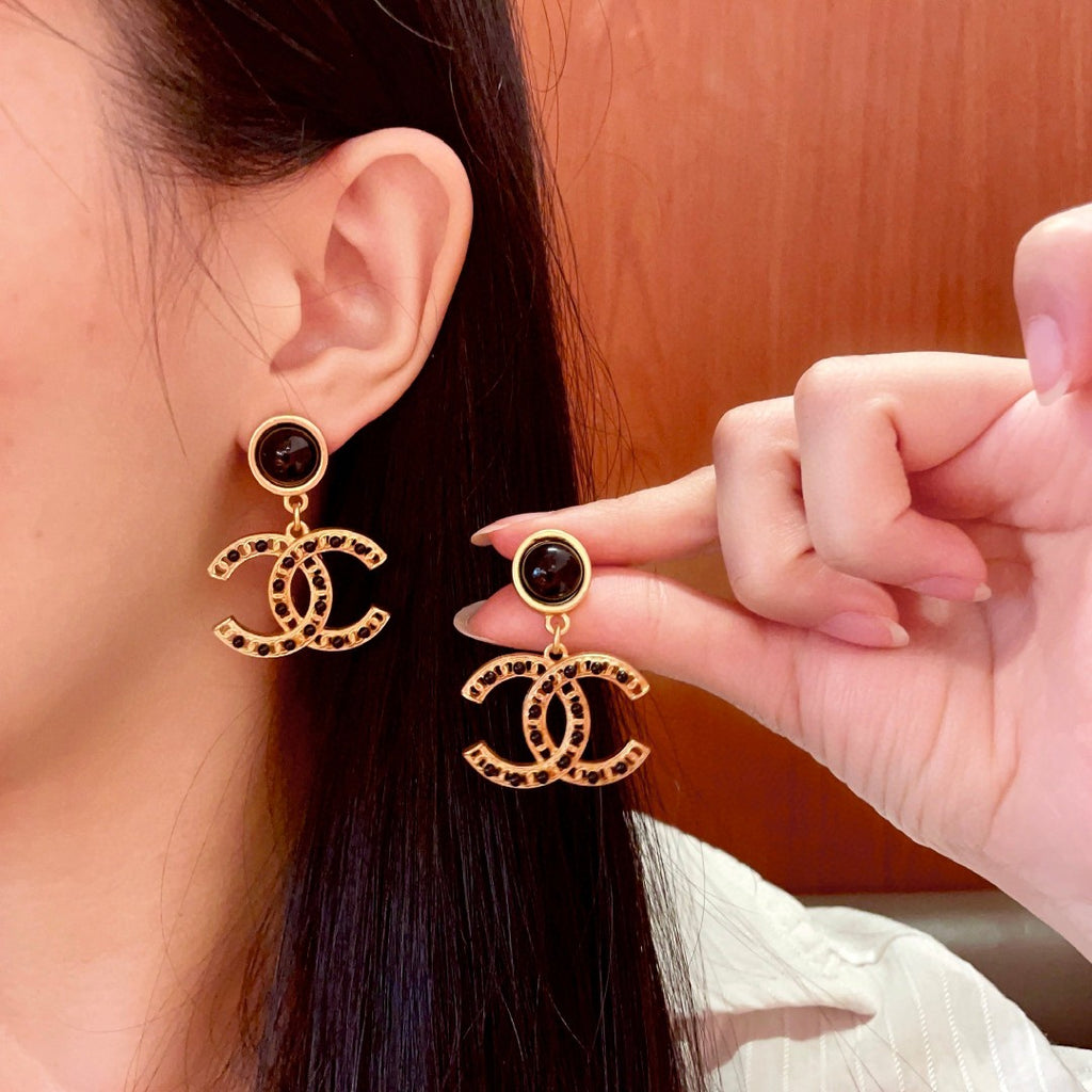 Chanel CC logo drop earrings in black and gold tone metal with black onyx studs and rhinestone embellishments