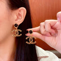 Chanel CC logo drop earrings in black and gold tone metal with black onyx studs and rhinestone embellishments