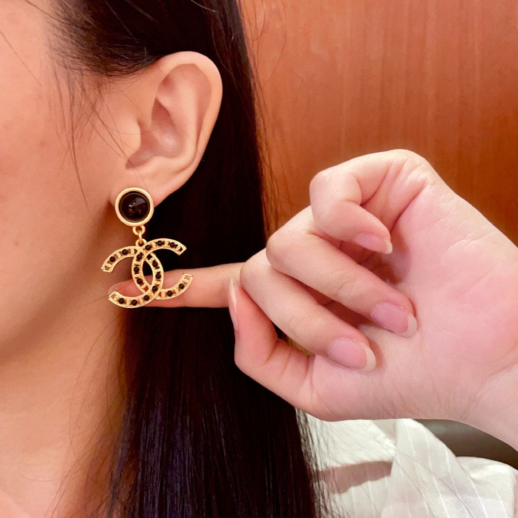 Chanel CC logo drop earrings in black and gold tone metal with black onyx studs and rhinestone embellishments