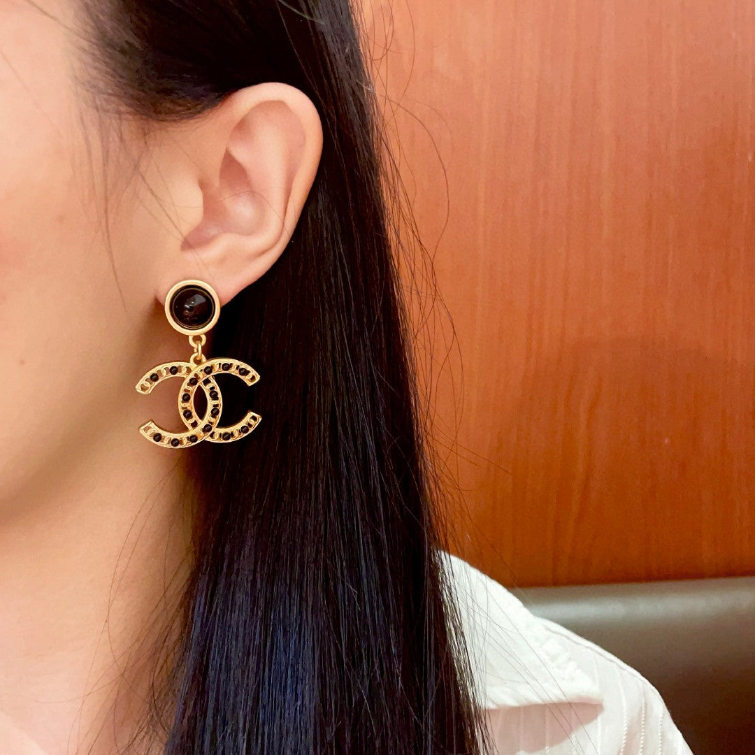 Chanel CC logo drop earrings in black and gold tone metal with black onyx studs and rhinestone embellishments