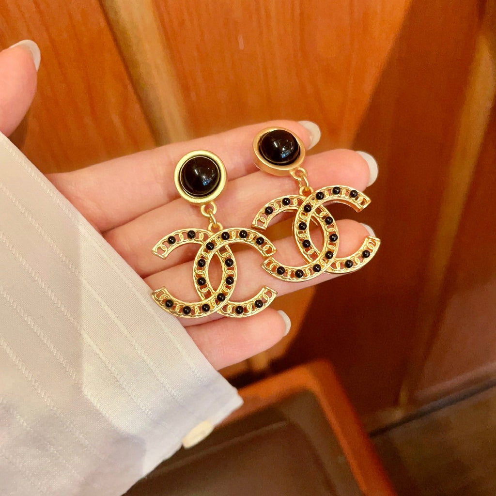 Chanel CC logo drop earrings in black and gold tone metal with black onyx studs and rhinestone embellishments