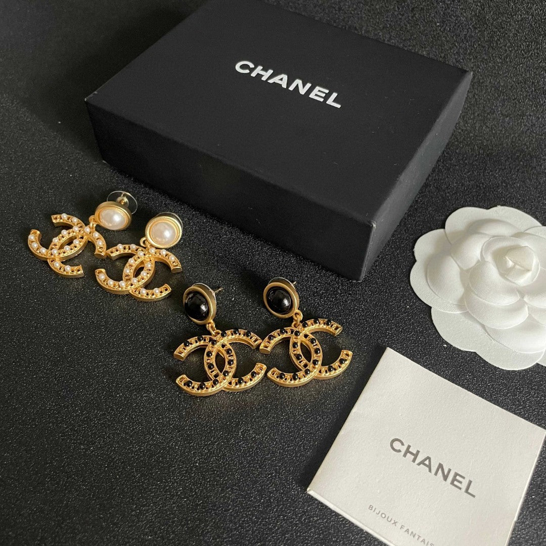 Chanel CC logo drop earrings in black and gold tone metal with black onyx studs and rhinestone embellishments