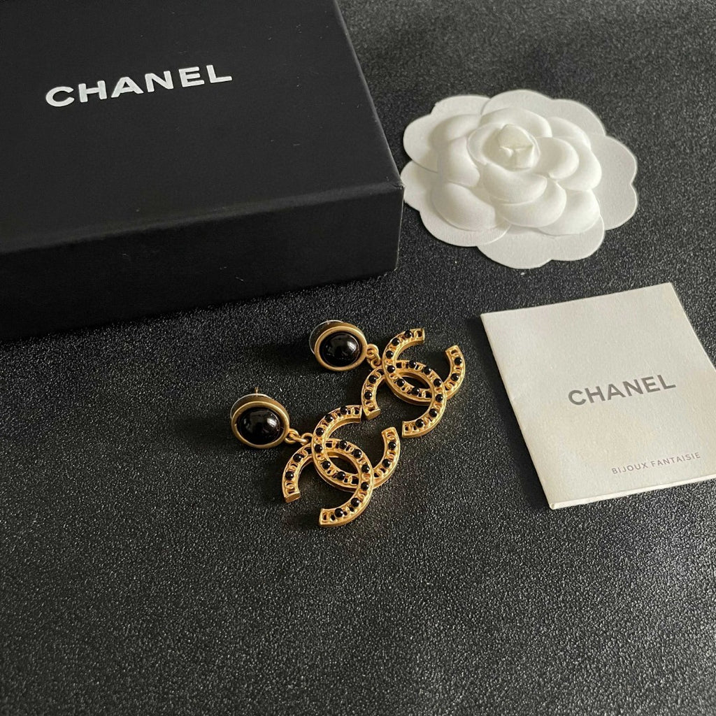 Chanel CC logo drop earrings in black and gold tone metal with black onyx studs and rhinestone embellishments