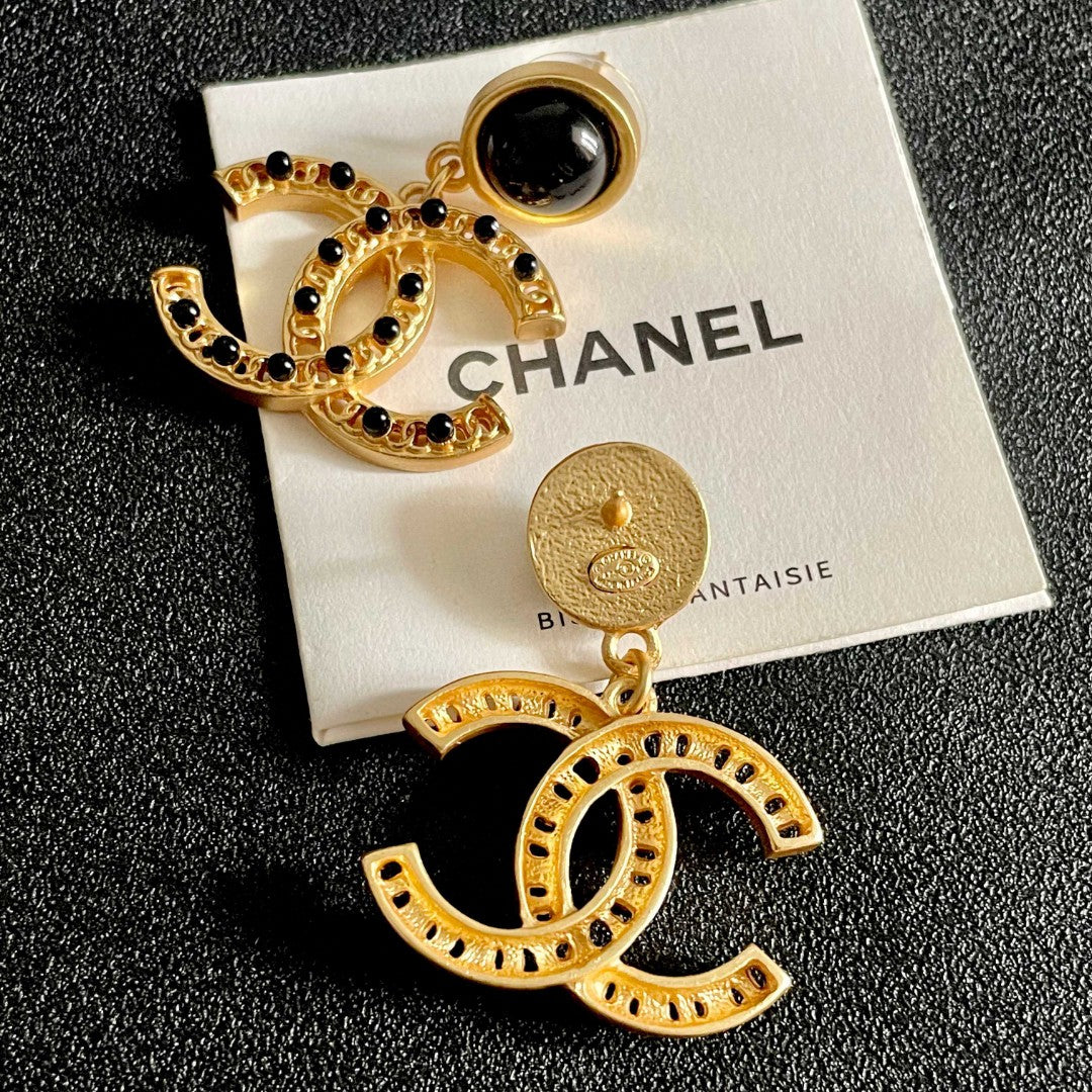 Chanel CC logo drop earrings in black and gold tone metal with black onyx studs and rhinestone embellishments
