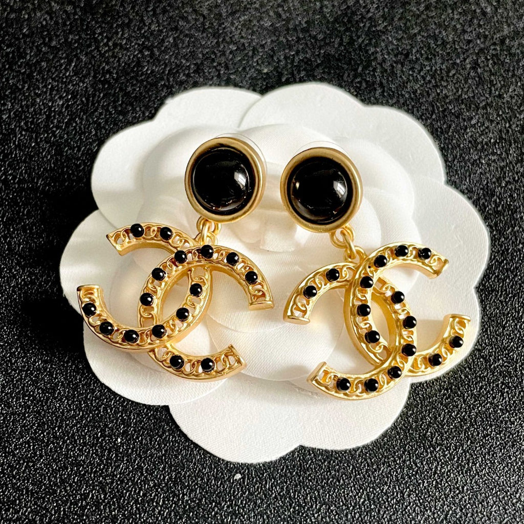 Chanel CC logo drop earrings in black and gold tone metal with black onyx studs and rhinestone embellishments