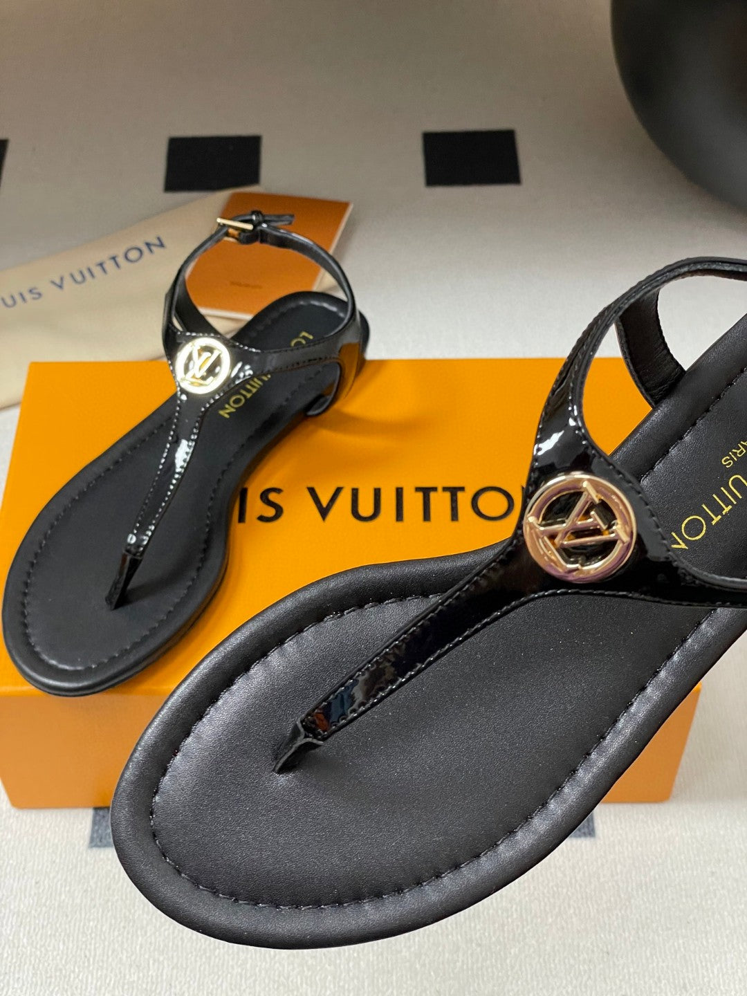 Louis Vuitton Sunkiss Flat Sandal in patent calf leather available in black, white, red, and silver