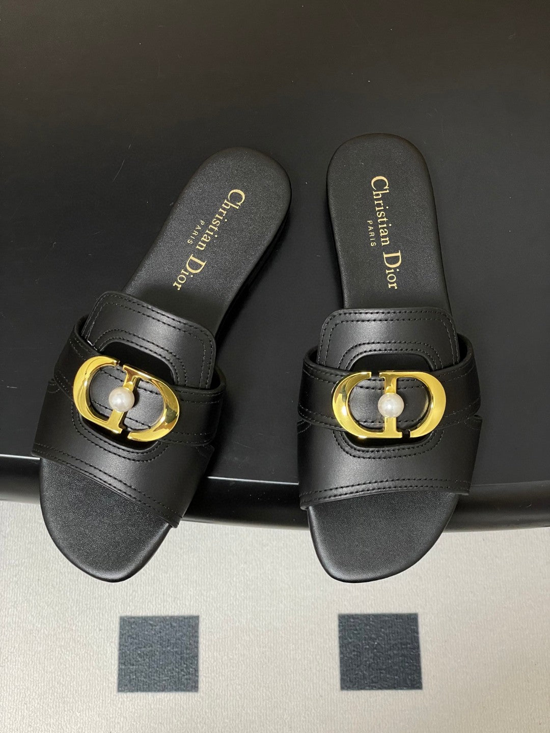 Christian Dior 30 Montaigne slide in black calfskin with a gold-finish metal 'CD' signature