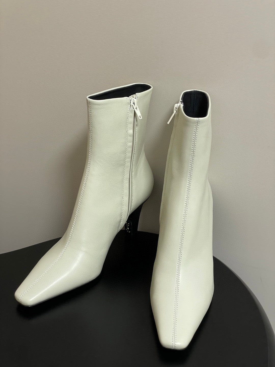 Saint Laurent Jill ankle boots in off-white smooth leather with a square pointed toe and a tapered heel featuring an inner Cassandre logo