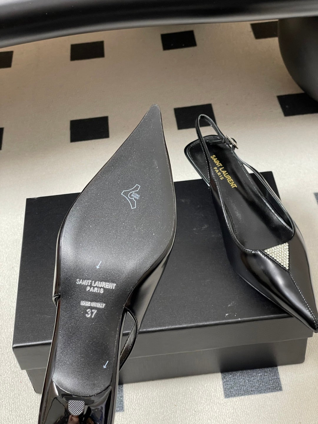 Saint Laurent Cherish 30 slingback pumps in black glazed calfskin leather with a rhinestone triangle detail