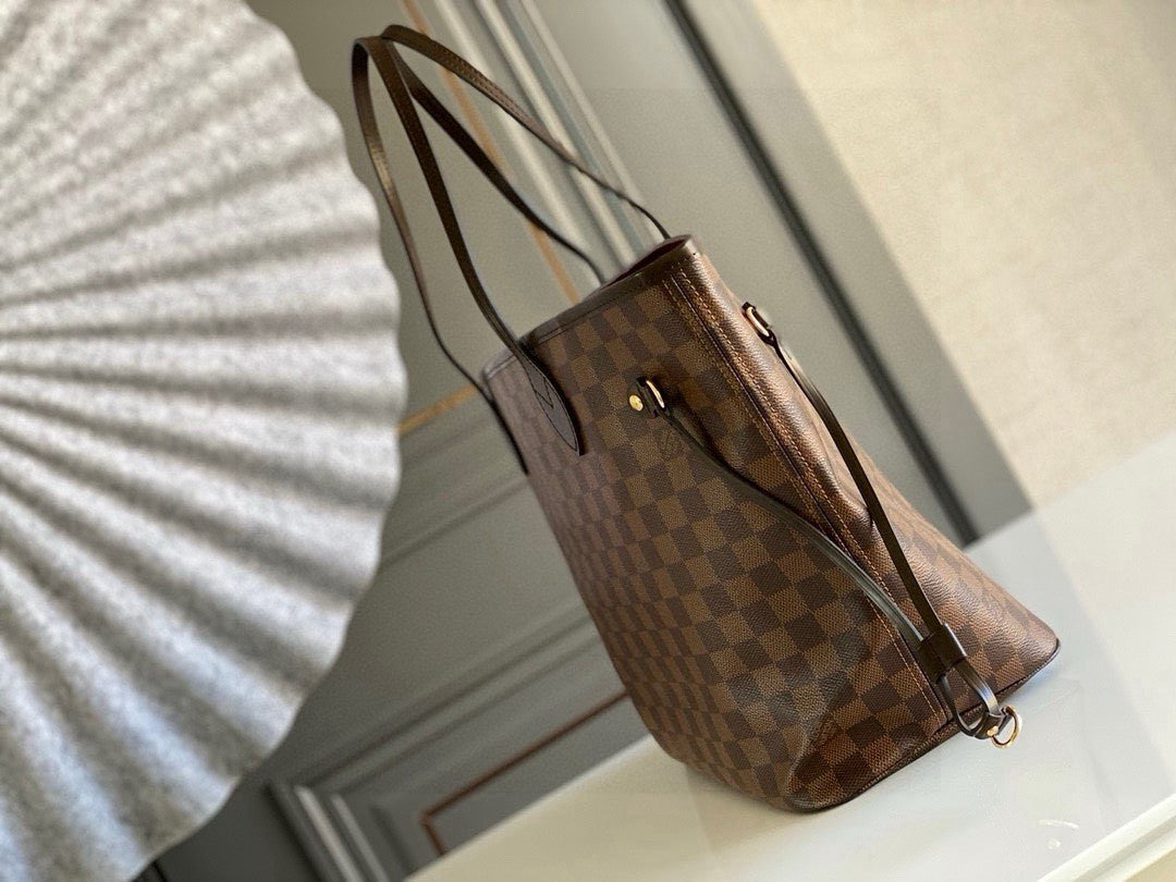Louis Vuitton Neverfull MM tote bag in the Damier Ebene canvas with a red interior lining